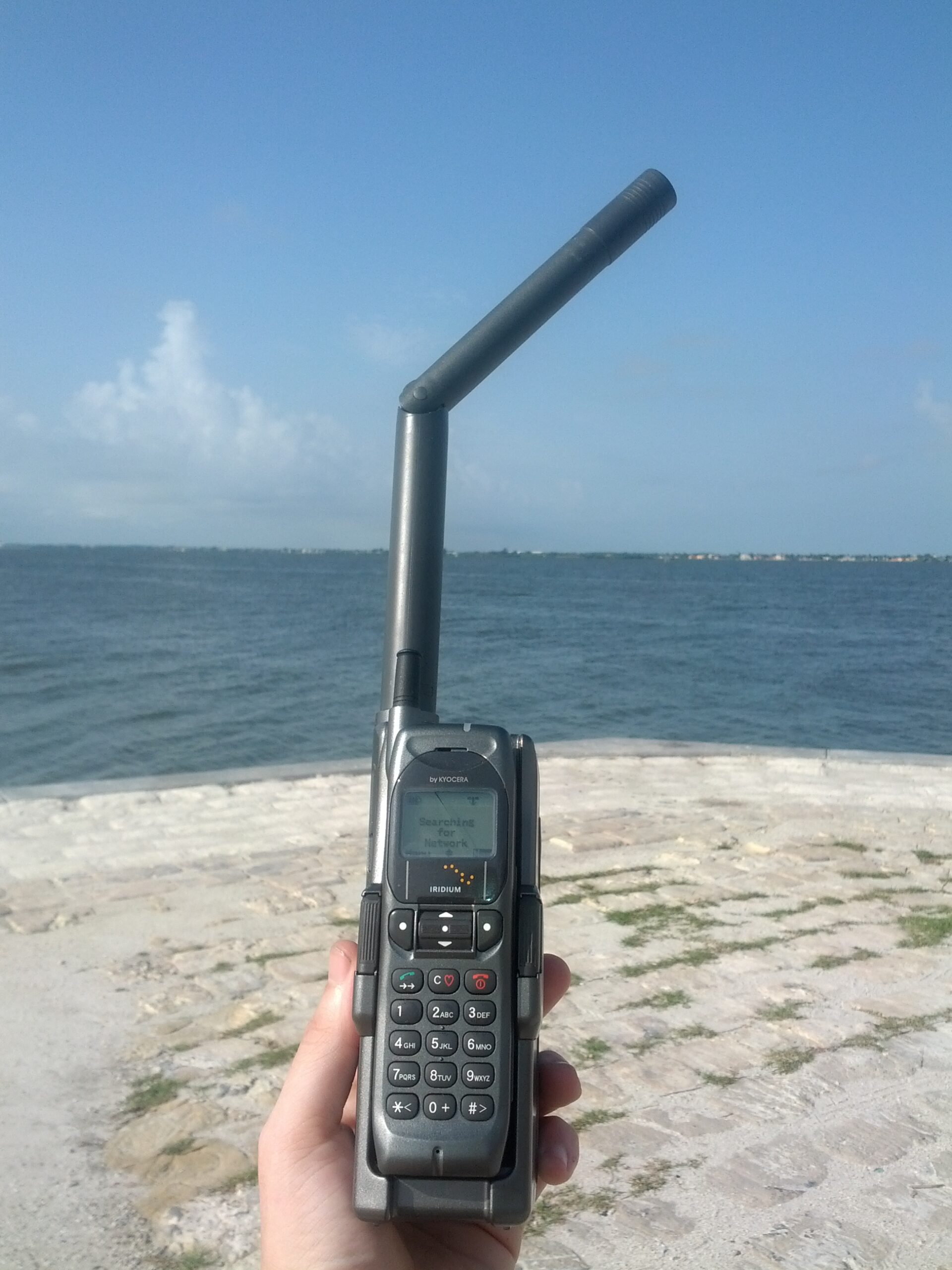 Iridium satellite phone with an antenna, screen and keypad.
